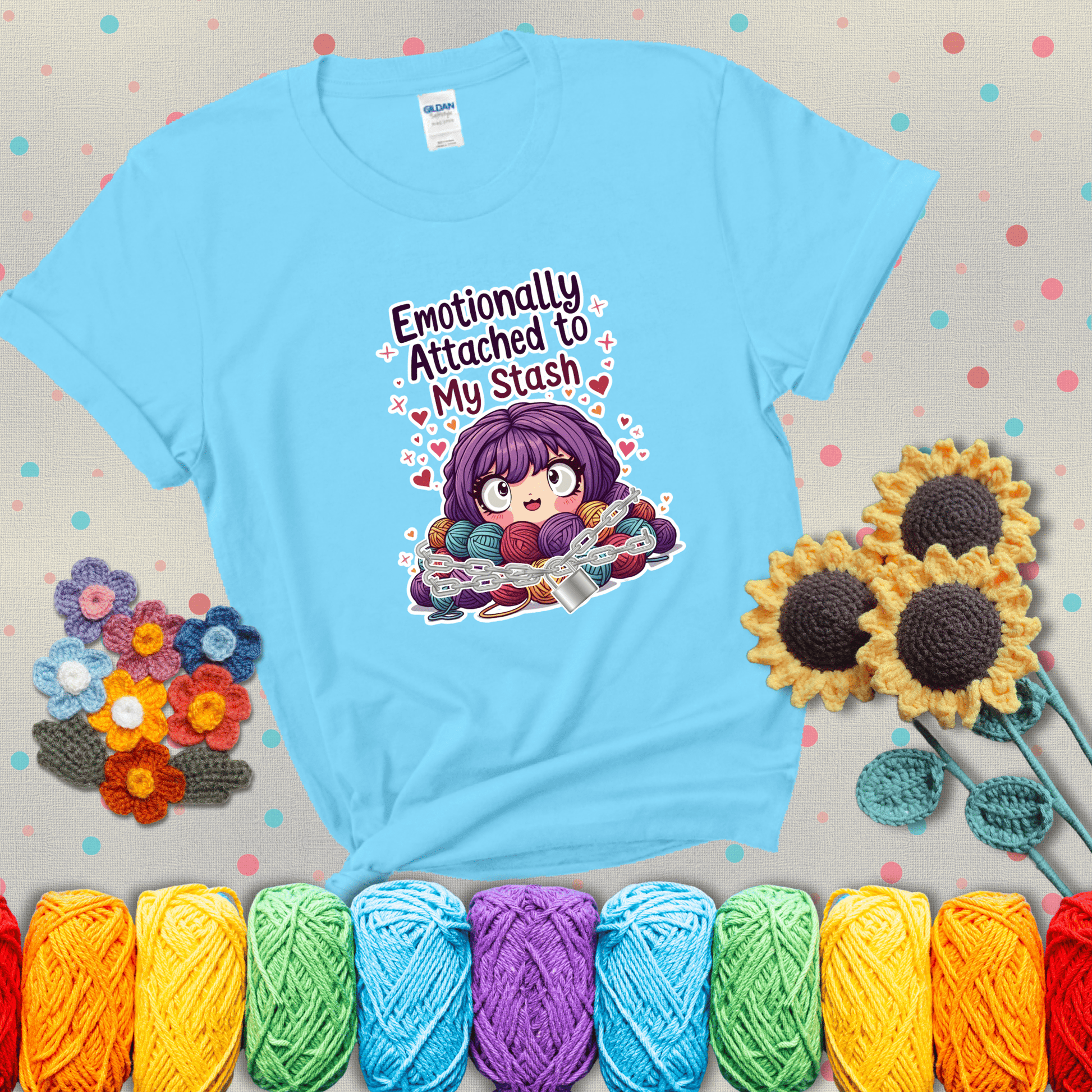Rows of colorful yarn skeins stacked with playful text. Text reads: “Emotionally Attached to My Stash.” A humorous shirt for fiber lovers with growing collections, showing a light blue tee with grey sunflower background