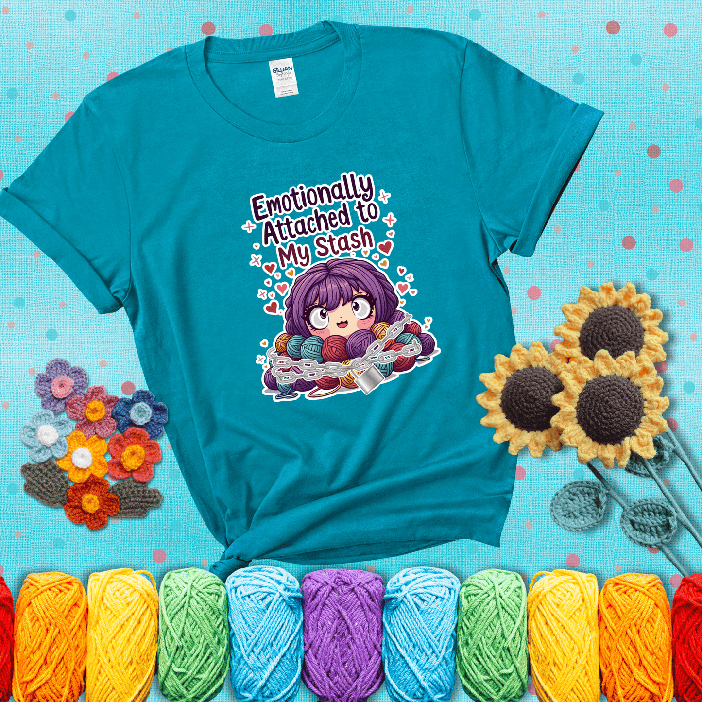 Rows of colorful yarn skeins stacked with playful text. Text reads: “Emotionally Attached to My Stash.” A humorous shirt for fiber lovers with growing collections, showing a blue-green tee with a teal sunflower background