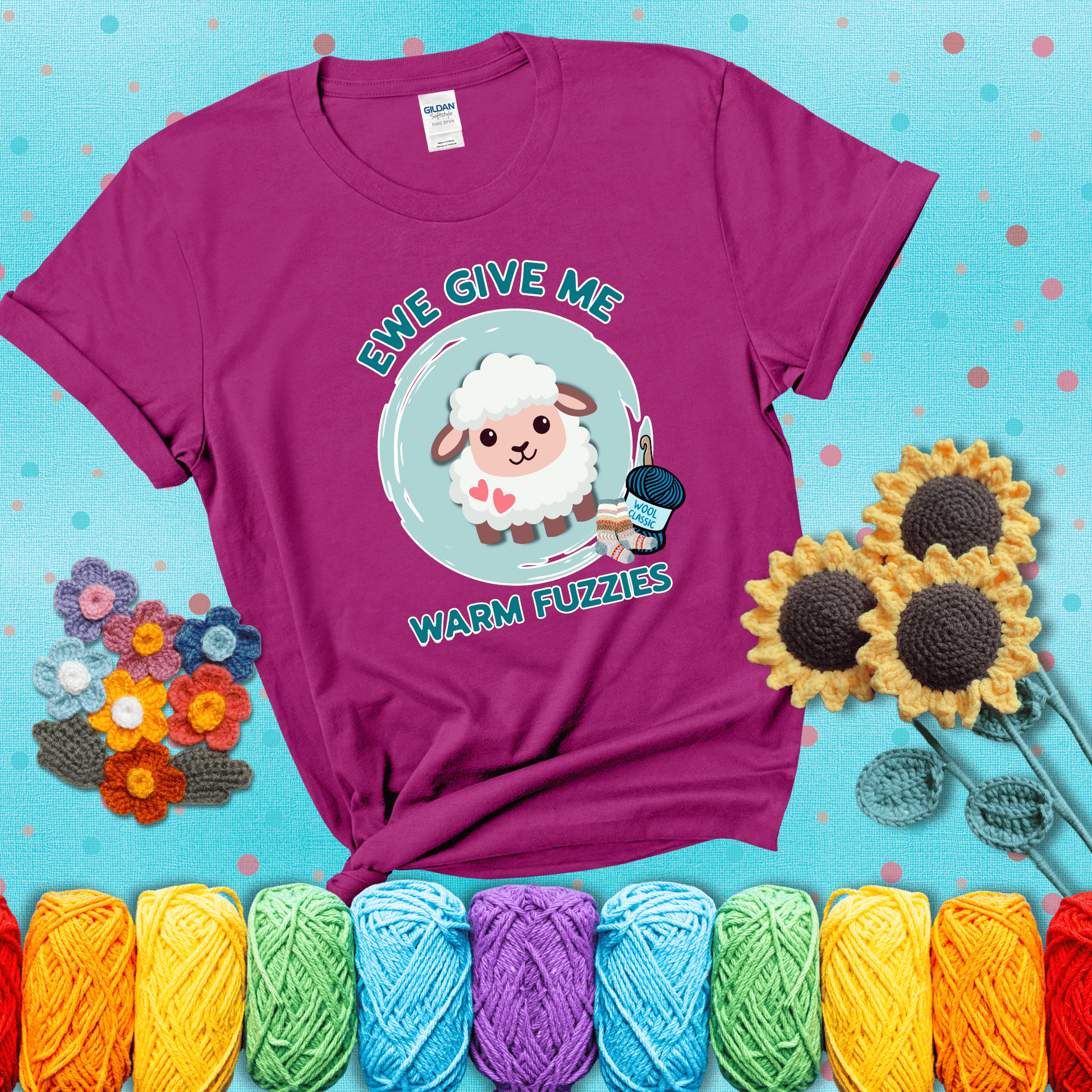 Cartoon sheep with pink hearts, wool socks, and yarn labeled “Wool Classic.” Text reads “Ewe Give Me Warm Fuzzies” showing a magenta tee with a teal sunflower background