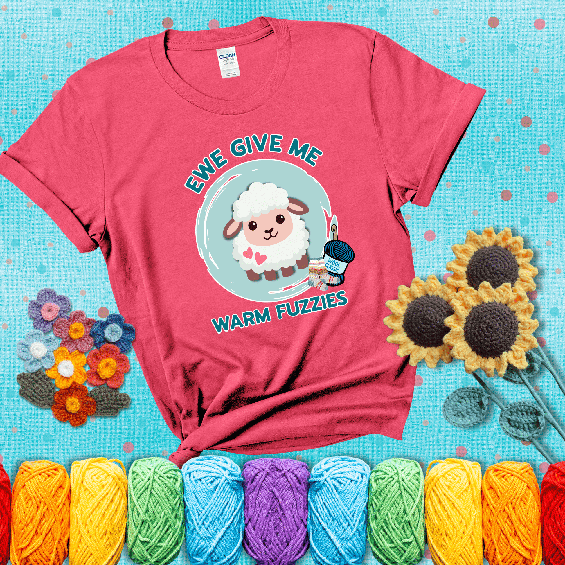 Cartoon sheep with pink hearts, wool socks, and yarn labeled “Wool Classic.” Text reads “Ewe Give Me Warm Fuzzies” showing a light red tee with a teal sunflower background