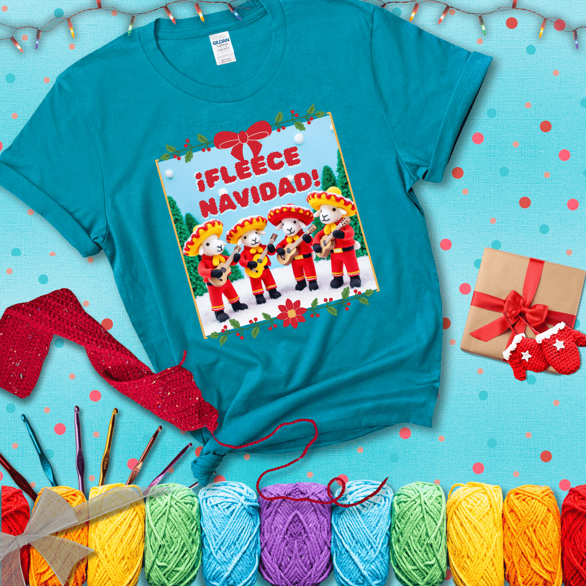 Four crocheted sheep dressed in red mariachi outfits with guitars, standing in a snowy scene under the phrase “¡Fleece Navidad!” showing a blue-green tee with a festive Christmas background
