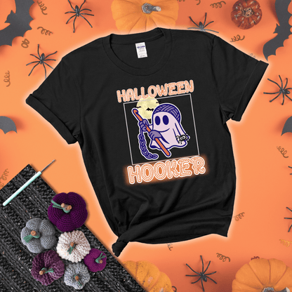 Cartoon ghost crocheter with a yarn ball head, crochet hook, bats, and text “Halloween Hooker,” a fun spooky tee for yarn lovers showing a black tee with a festive Halloween background
