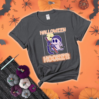 Cartoon ghost crocheter with a yarn ball head, crochet hook, bats, and text “Halloween Hooker,” a fun spooky tee for yarn lovers showing a dark grey tee with a festive Halloween background