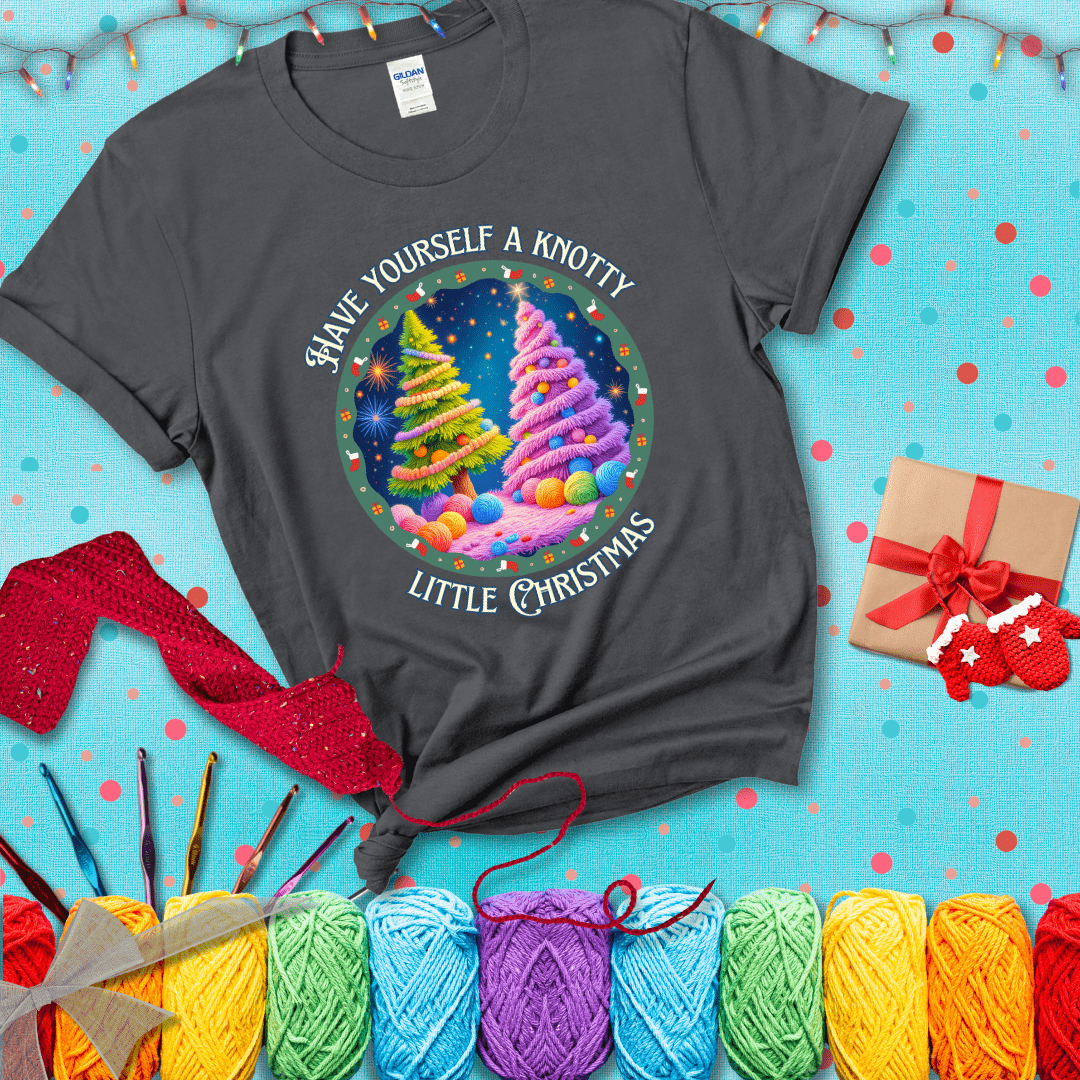 Two yarn-covered Christmas trees wrapped in colorful strands of yarn, with the phrase "Have Yourself a Knotty Little Christmas" encircling the scene showing a dark grey tee with a festive Christmas background