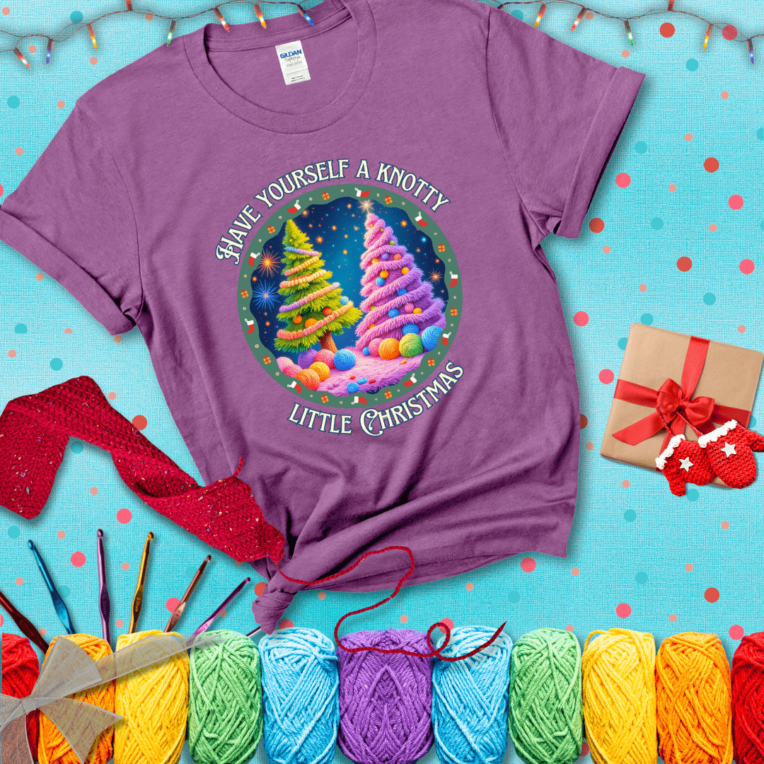 Two yarn-covered Christmas trees wrapped in colorful strands of yarn, with the phrase "Have Yourself a Knotty Little Christmas" encircling the scene showing a light purple tee with a festive Christmas background