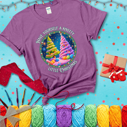Two yarn-covered Christmas trees wrapped in colorful strands of yarn, with the phrase "Have Yourself a Knotty Little Christmas" encircling the scene showing a light purple tee with a festive Christmas background