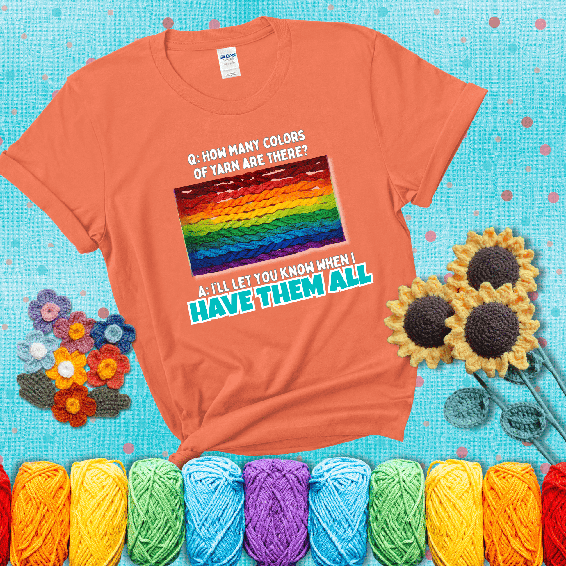 Rainbow skeins of yarn stacked in color gradient with playful question: “How many colors of yarn are there?” Answer: “I'll let you know when I have them all” showing a light orange tee with a teal sunflower background