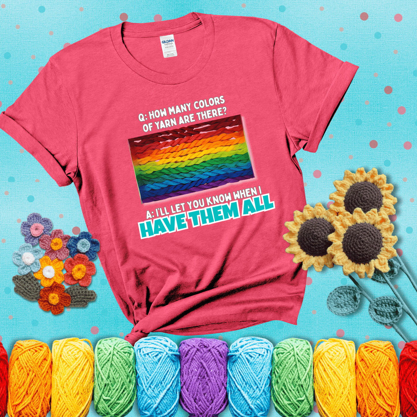 Rainbow skeins of yarn stacked in color gradient with playful question: “How many colors of yarn are there?” Answer: “I'll let you know when I have them all” showing a light red tee with a teal sunflower background