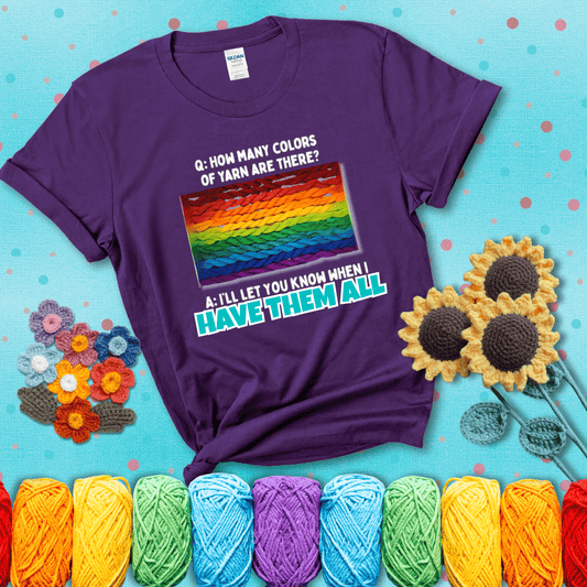 Rainbow skeins of yarn stacked in color gradient with playful question: “How many colors of yarn are there?” Answer: “I'll let you know when I have them all” showing a purple tee with a teal sunflower background