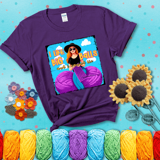 Bold cartoon image of a woman crocheting between two giant purple yarn balls with the phrase “I like big balls and I cannot lie” in retro fonts showing a purple tee with a teal sunflower background