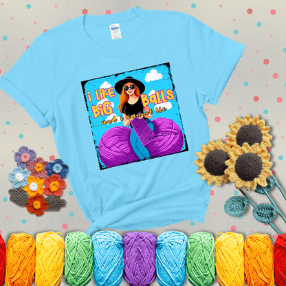 Bold cartoon image of a woman crocheting between two giant purple yarn balls with the phrase “I like big balls and I cannot lie” in retro fonts showing a light blue tee with grey sunflower background