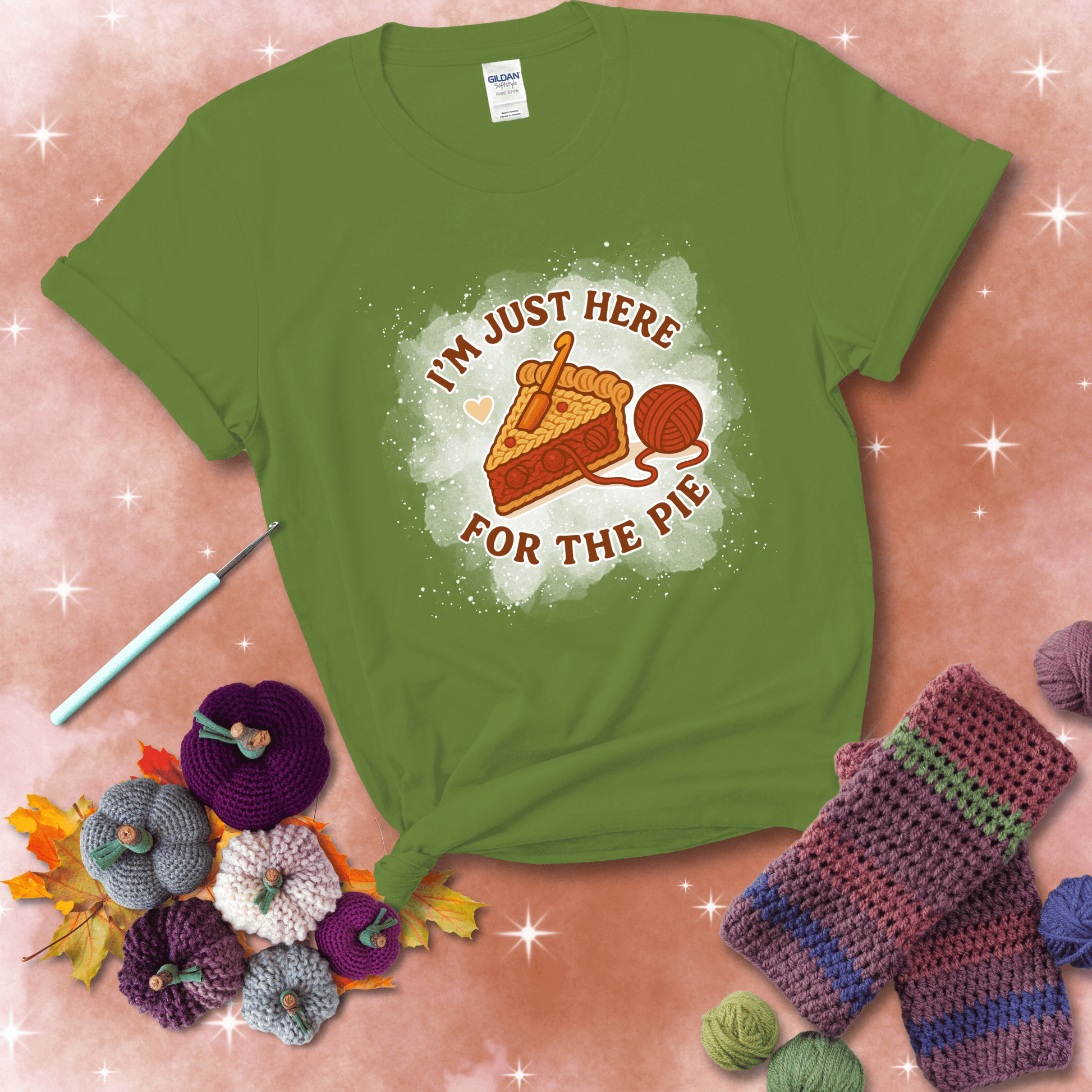 A slice of cherry pie with a crochet hook tucked in the filling and yarn trailing out, blending baking with crochet fun, showing a bright green tee with a festive Fall background