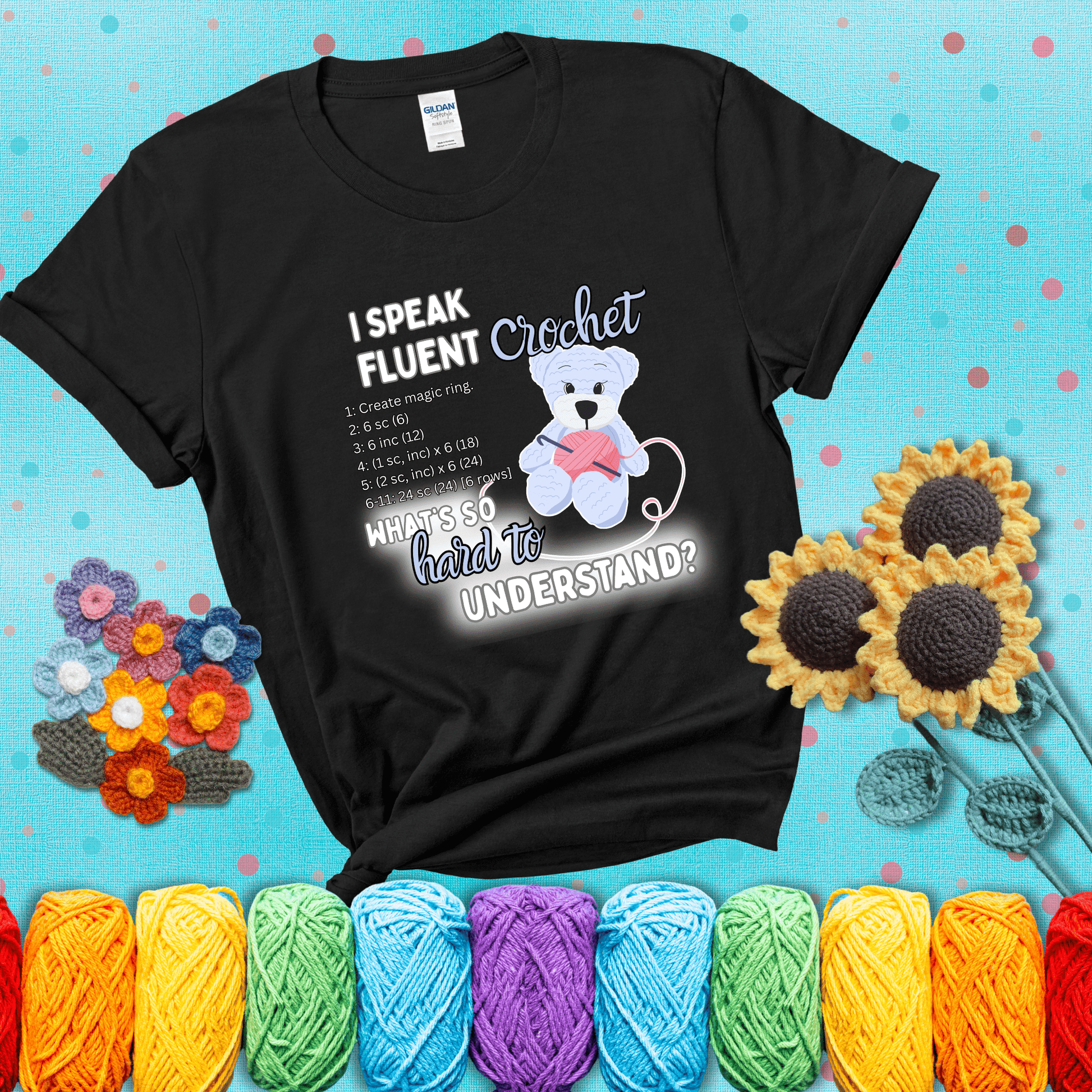 A cute crochet bear holding a yarn ball, surrounded by a short crochet pattern. The phrase reads “I Speak Fluent Crochet – What’s so hard to understand?” showing a black tee with a teal sunflower background