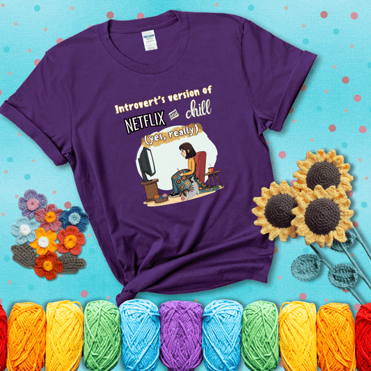 A girl with a crochet hook sits under a granny square blanket watching TV, with yarn, a coffee mug, and a cat at her feet. Text says “Introvert’s version of Netflix and chill (yes, really)," showing a purple tee with a teal sunflower background