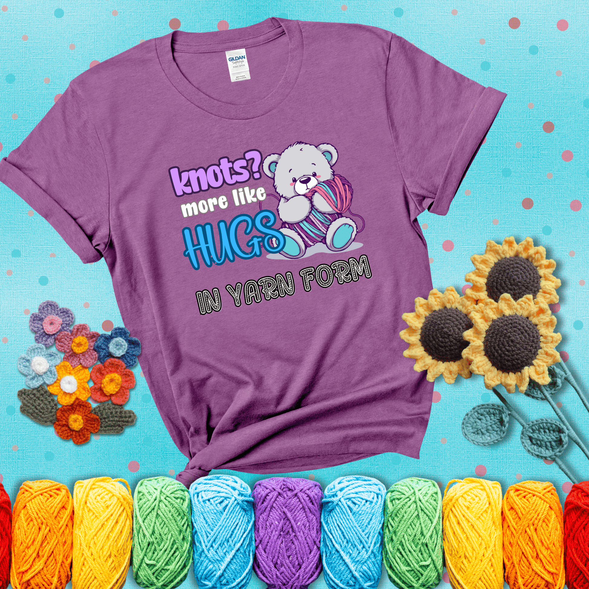 Cute teddy bear holding colorful yarn ball with hearts. Text reads: “Knots? More Like Hugs in Yarn Form.” Perfect for cozy gift-givers and yarn lovers, showing a light purple tee with a teal sunflower background