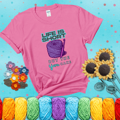 No regrets, just yarn Design reads 'Life Is Short. Buy The Yarn (Cake)' , perfect crochet gift for yarn lovers, showing a pink tee with a teal sunflower background