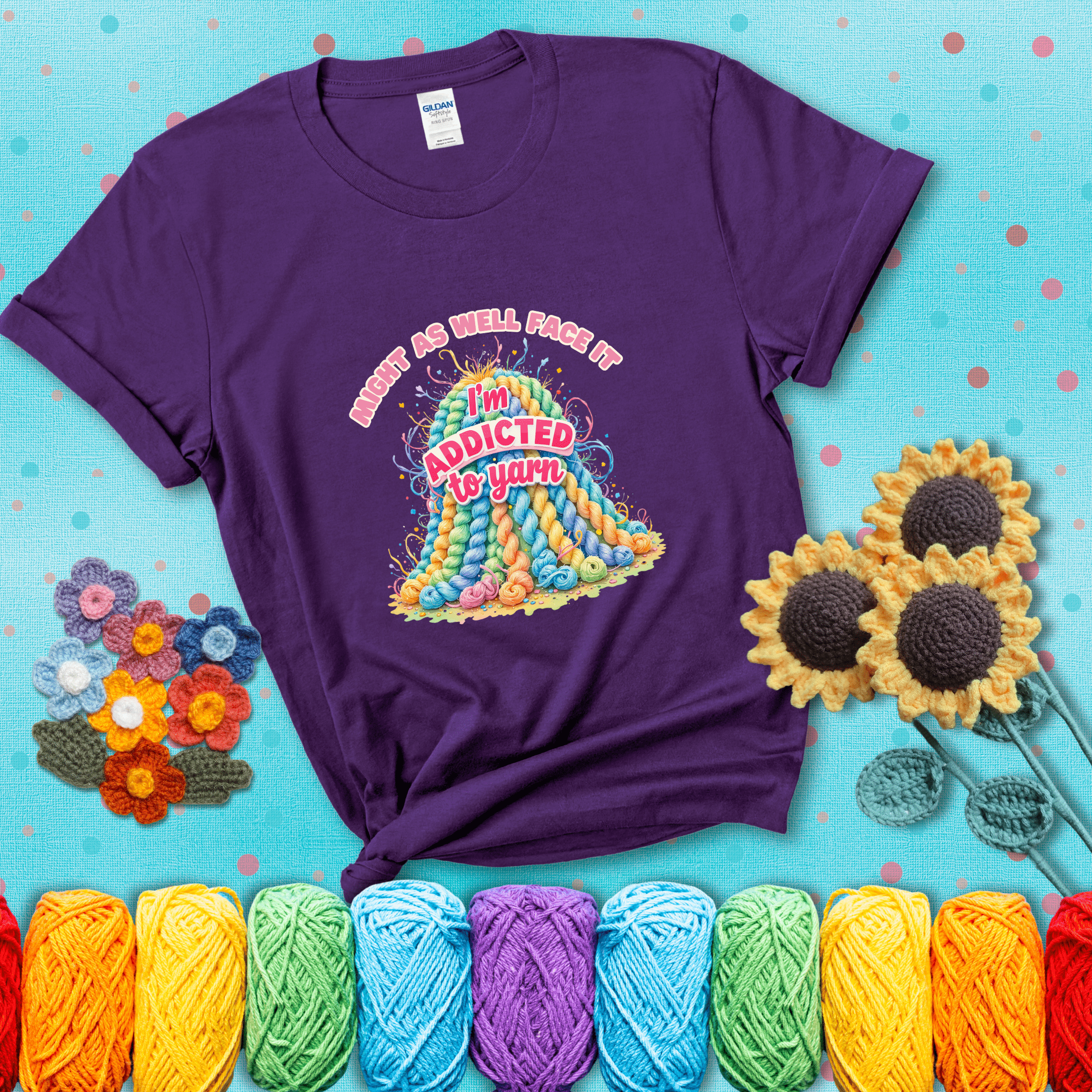 Colorful mountain of pastel yarn hanks with the phrase “Might as well face it, I’m addicted to yarn” in playful pink and red lettering showing a purple tee with a teal sunflower background
