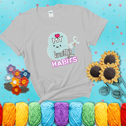 Smiling yarn ball and hook with text “Love My Knotty Habits” - cute crochet shirt with playful design for makers, showing a light grey tee with a teal sunflower background