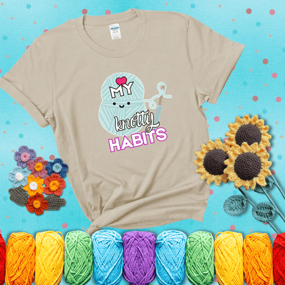 Smiling yarn ball and hook with text “Love My Knotty Habits” - cute crochet shirt with playful design for makers, showing a beige tee with a teal sunflower background