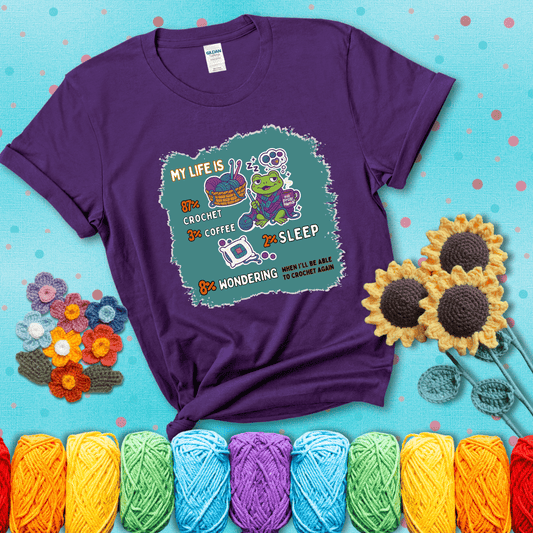 A relaxed frog crocheting while sipping coffee, surrounded by yarn and dreaming of more yarn. Includes whimsical text dividing life into percentages: 87% crochet, 3% coffee, 2% sleep, 8% wondering when to crochet again showing a purple tee with a teal sunflower background