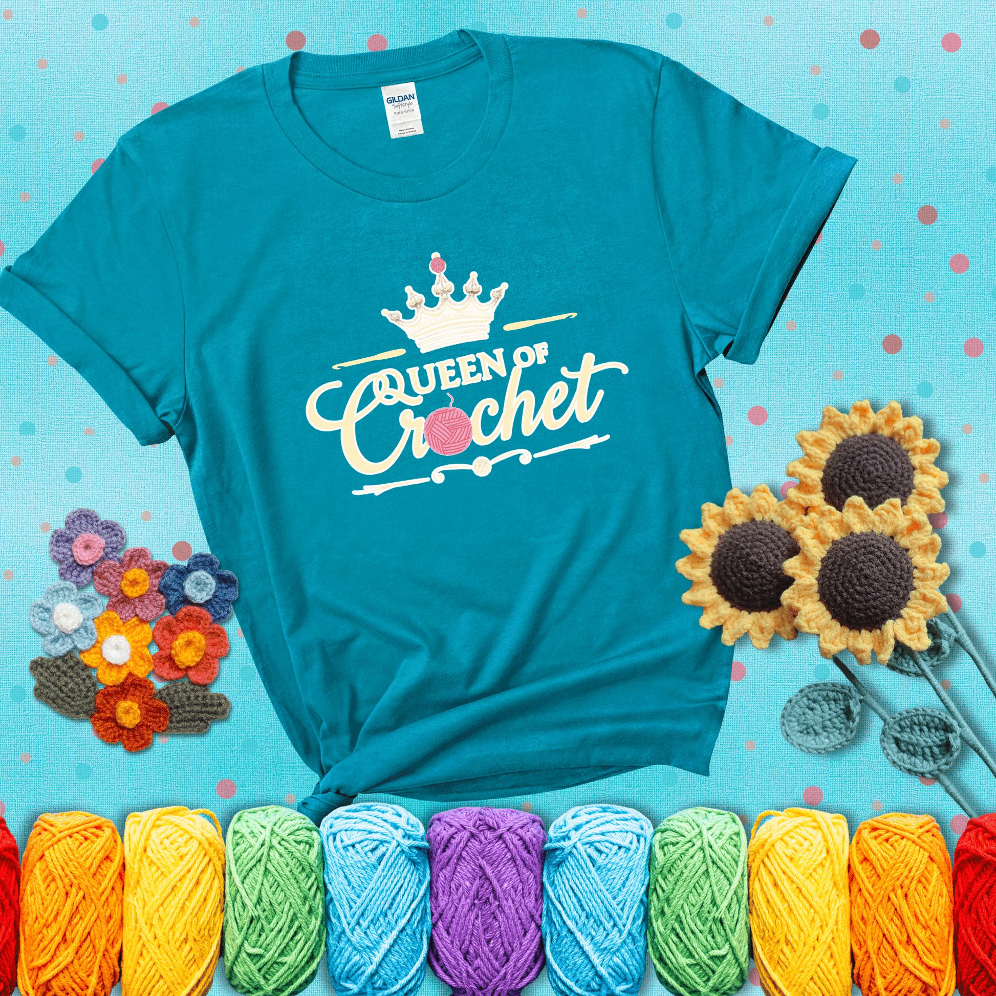Crown-topped design reads “Queen of Crochet” with elegant script and two pink yarn balls, one forming the letter “o” and another atop the crown showing a blue-green tee with a teal sunflower background