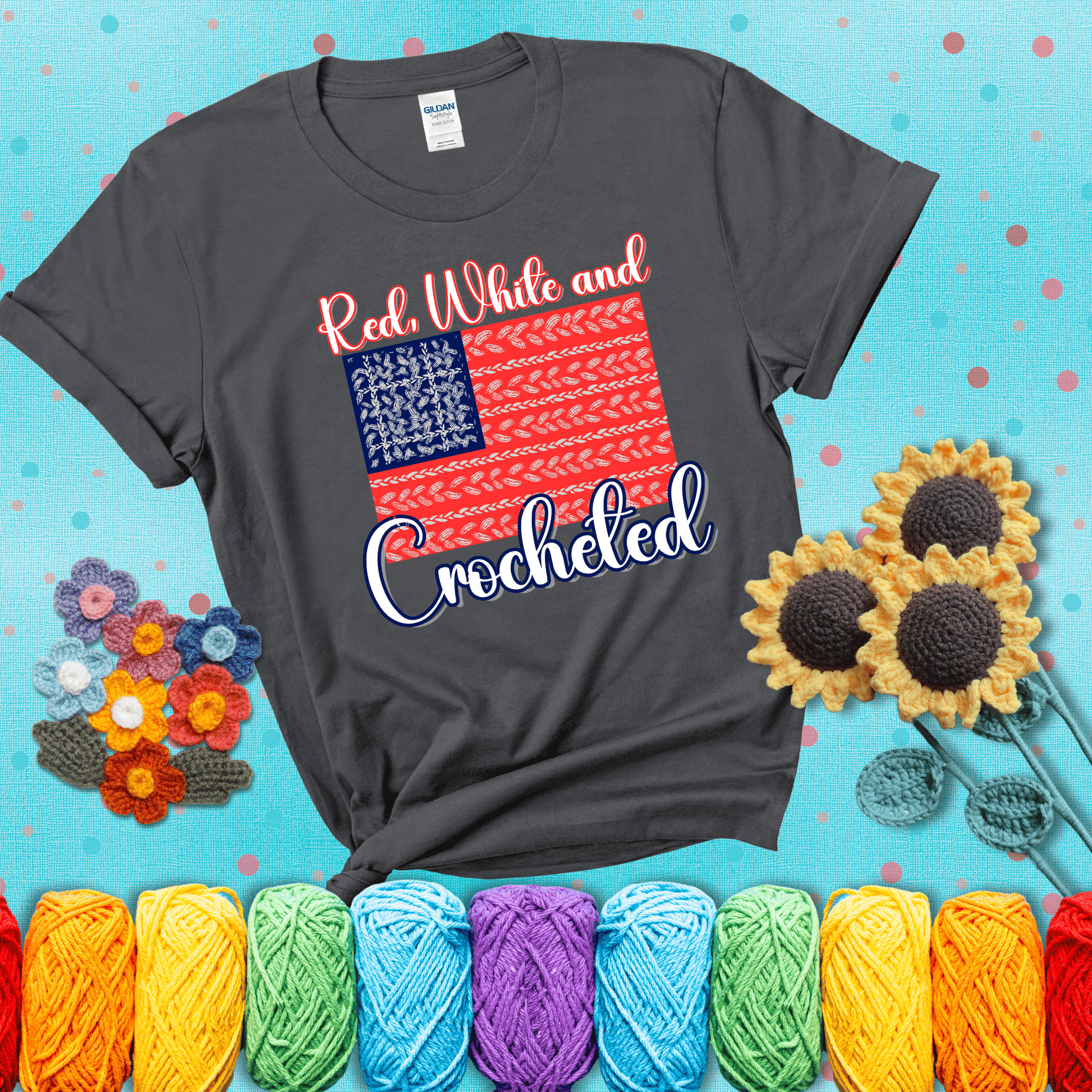 Patriotic crochet-themed American flag design with red and white yarn stitches forming the stripes and blue and white stitches as stars, showing a dark grey tee with a teal sunflower background