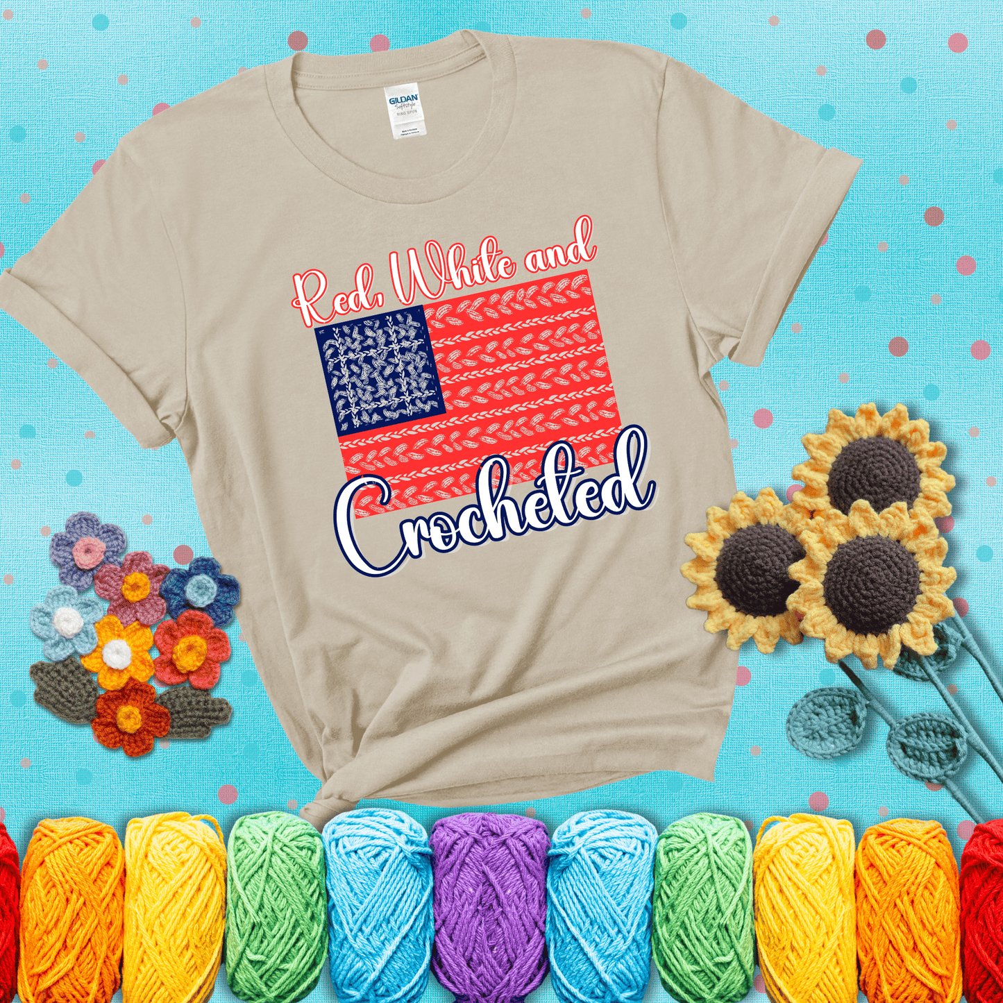 Patriotic crochet-themed American flag design with red and white yarn stitches forming the stripes and blue and white stitches as stars, showing a beige tee with a teal sunflower background