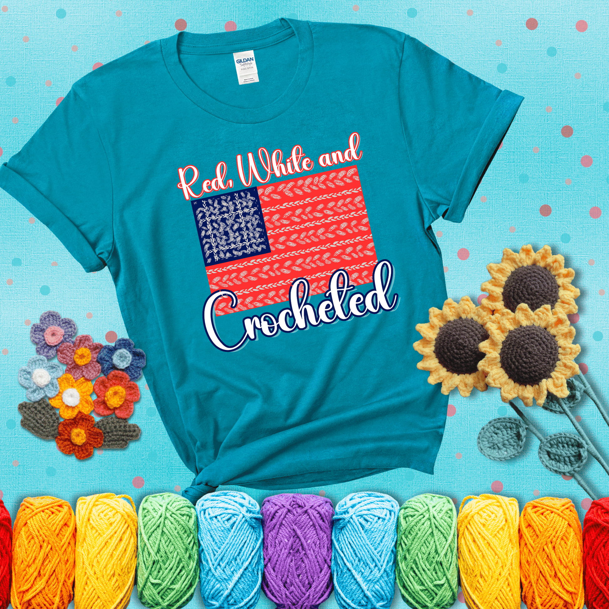 Patriotic crochet-themed American flag design with red and white yarn stitches forming the stripes and blue and white stitches as stars, showing a blue-green tee with a teal sunflower background