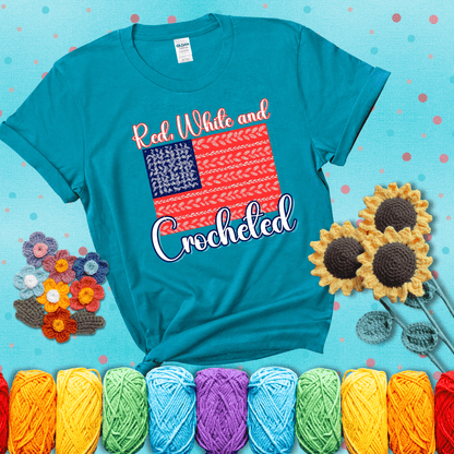 Patriotic crochet-themed American flag design with red and white yarn stitches forming the stripes and blue and white stitches as stars, showing a blue-green tee with a teal sunflower background