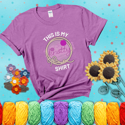 A playful design with the phrase "This is my knotty shirt" inside a rope circle, featuring a yarn ball and a crochet hook forming the word "knotty" showing a light purple tee with a teal sunflower background