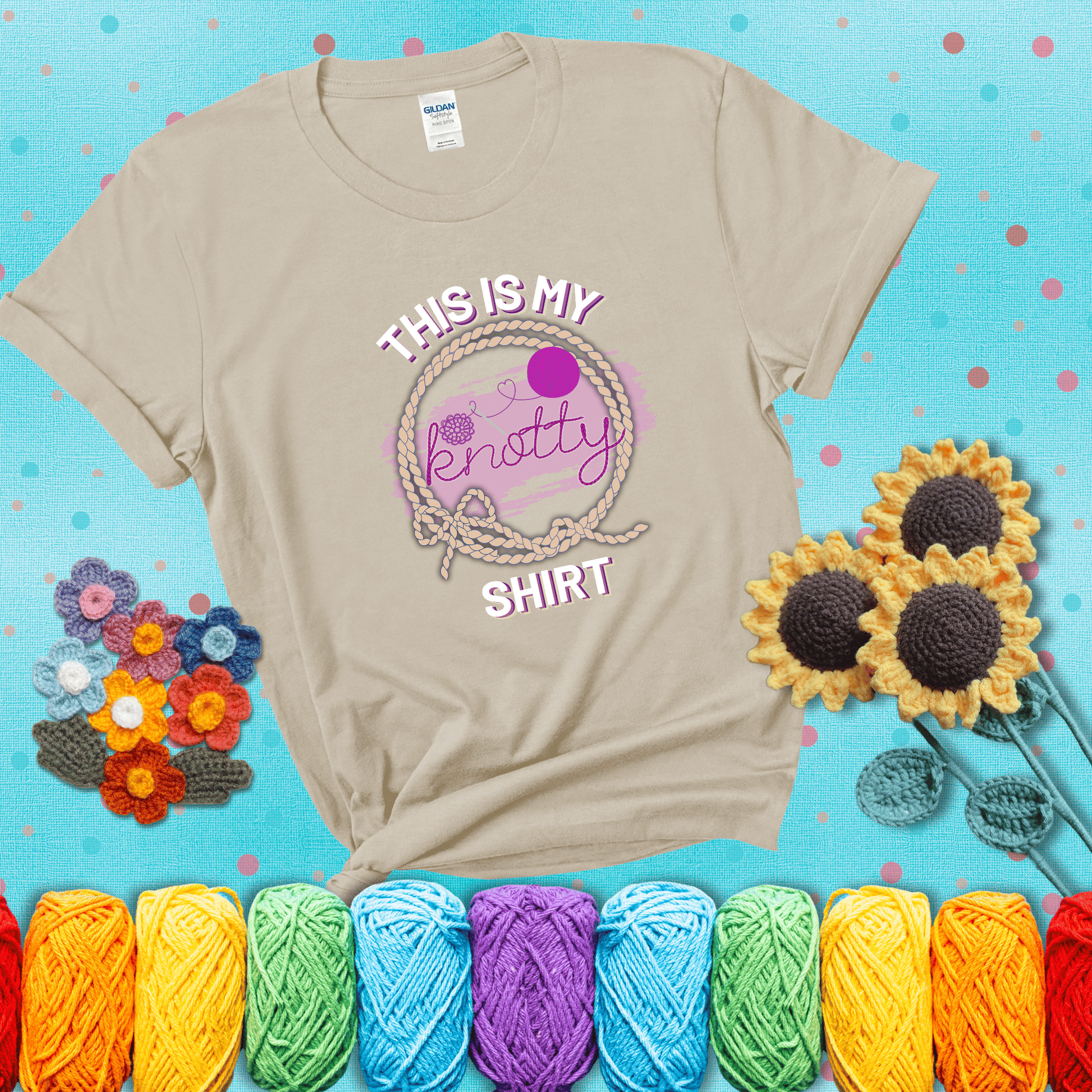 A playful design with the phrase "This is my knotty shirt" inside a rope circle, featuring a yarn ball and a crochet hook forming the word "knotty" showing a beige tee with a teal sunflower background