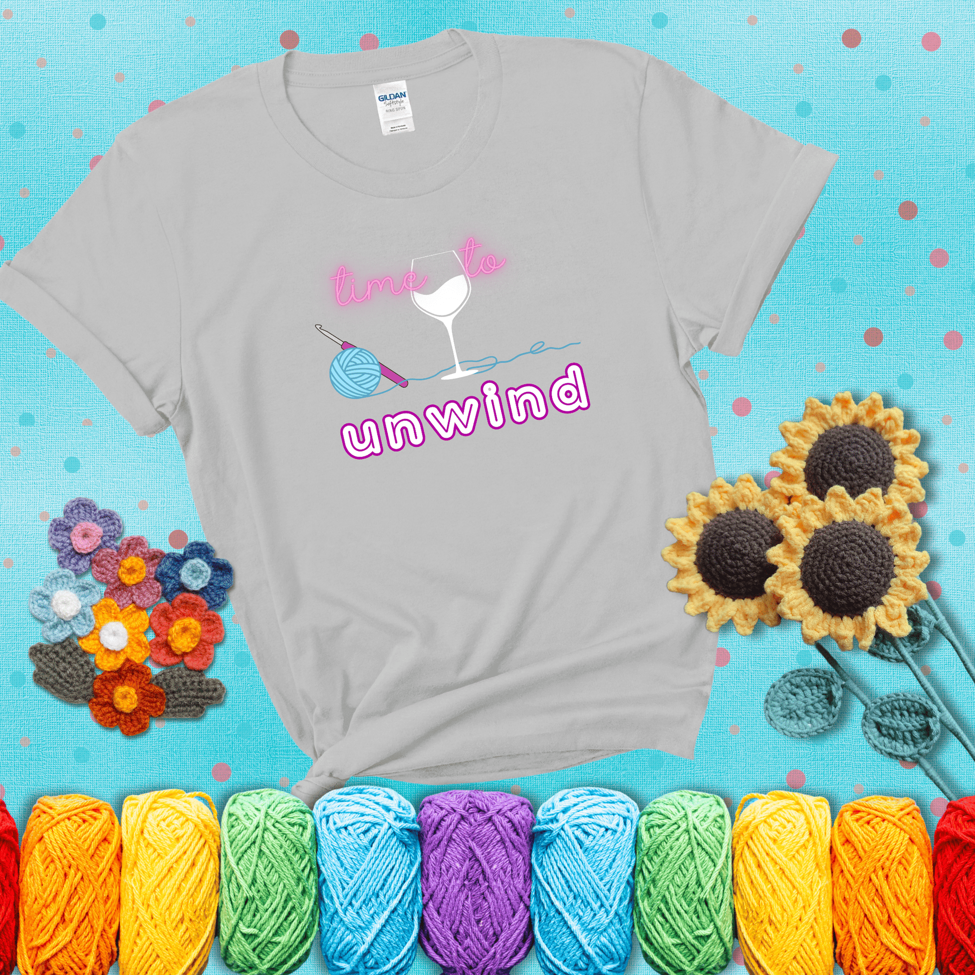 Wine down with your yarn out Design reads 'Time To Unwind' , perfect crochet gift for yarn lovers showing a light grey tee with a teal sunflower background
