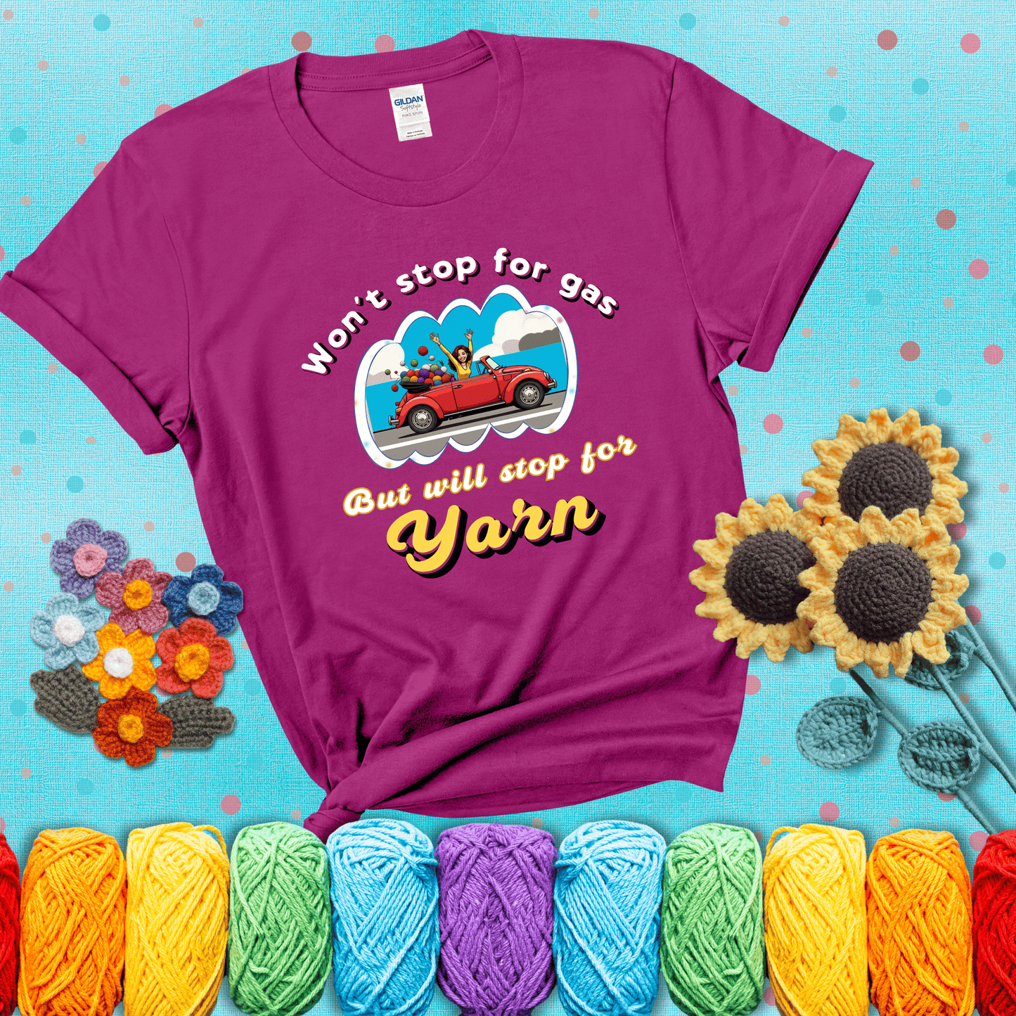 Woman joyfully driving a red convertible overflowing with yarn balls, paired with bold retro lettering and a playful slogan showing a magenta tee with a teal sunflower background