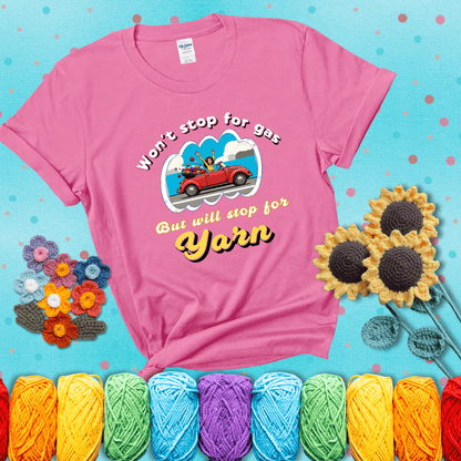 Woman joyfully driving a red convertible overflowing with yarn balls, paired with bold retro lettering and a playful slogan showing a pink tee with a teal sunflower background