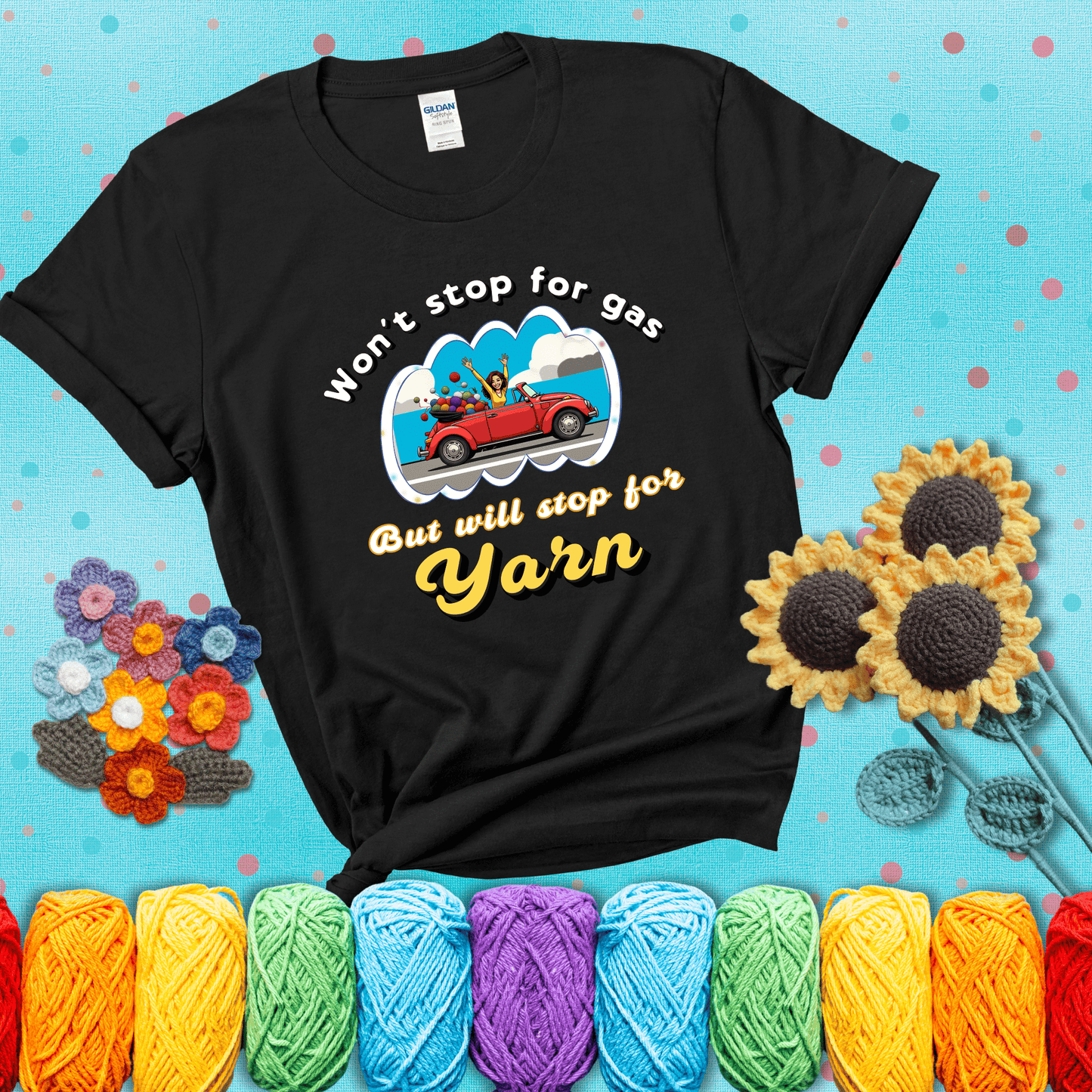 Woman joyfully driving a red convertible overflowing with yarn balls, paired with bold retro lettering and a playful slogan showing a black tee with a teal sunflower background