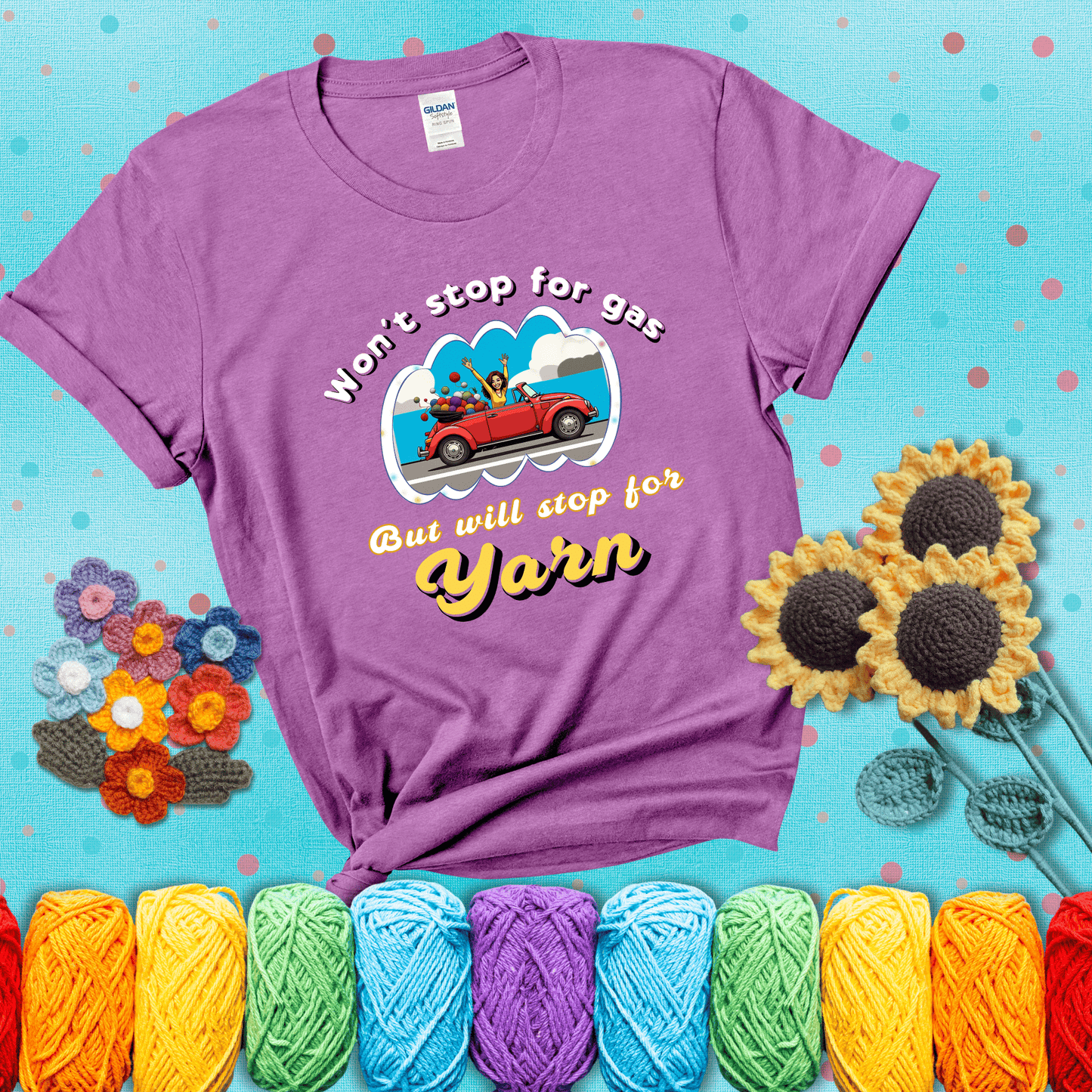 Woman joyfully driving a red convertible overflowing with yarn balls, paired with bold retro lettering and a playful slogan showing a light purple tee with a teal sunflower background