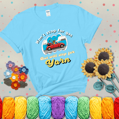 Woman joyfully driving a red convertible overflowing with yarn balls, paired with bold retro lettering and a playful slogan showing a light blue tee with grey sunflower background