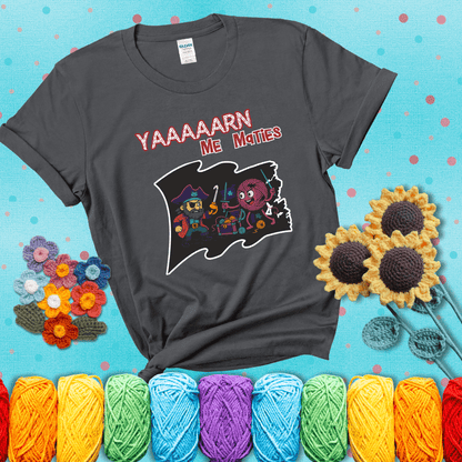 A pirate with a crochet hook for a hand duels a fierce yarn ball wielding knitting needles, standing in front of a treasure chest filled with yarn showing a dark grey tee with a teal sunflower background