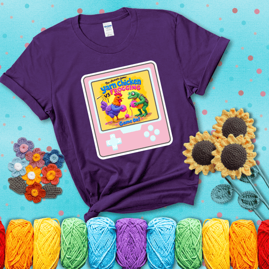 A colorful chicken and frog holding pink yarn face off inside a retro handheld game screen with the title “The ultimate game: Yarn Chicken vs. Frogging – Game On!” showing a purple tee with a teal sunflower background