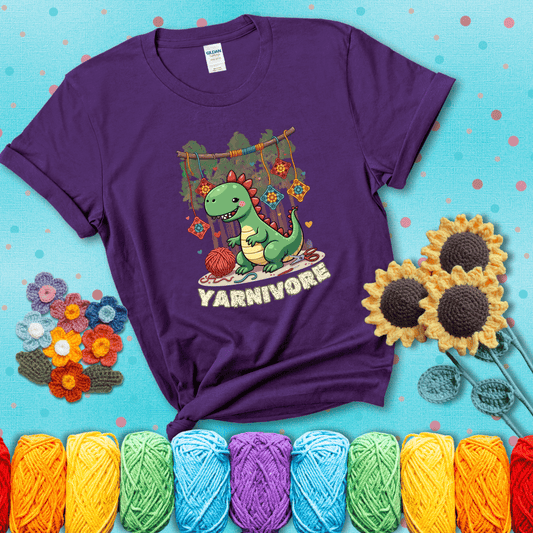 Silly dinosaur chomping on yarn skeins. Text reads: “Yarnivore.” A fun and quirky tee for yarn-obsessed crafters with big appetites, showing a purple tee with a teal sunflower background