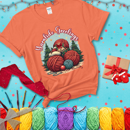 Pile of colorful yarn balls with bells, bows, and trees, with the phrase “Yarntide Greetings.” Cozy and festive holiday crochet tee, showing a light orange tee with a festive Christmas background