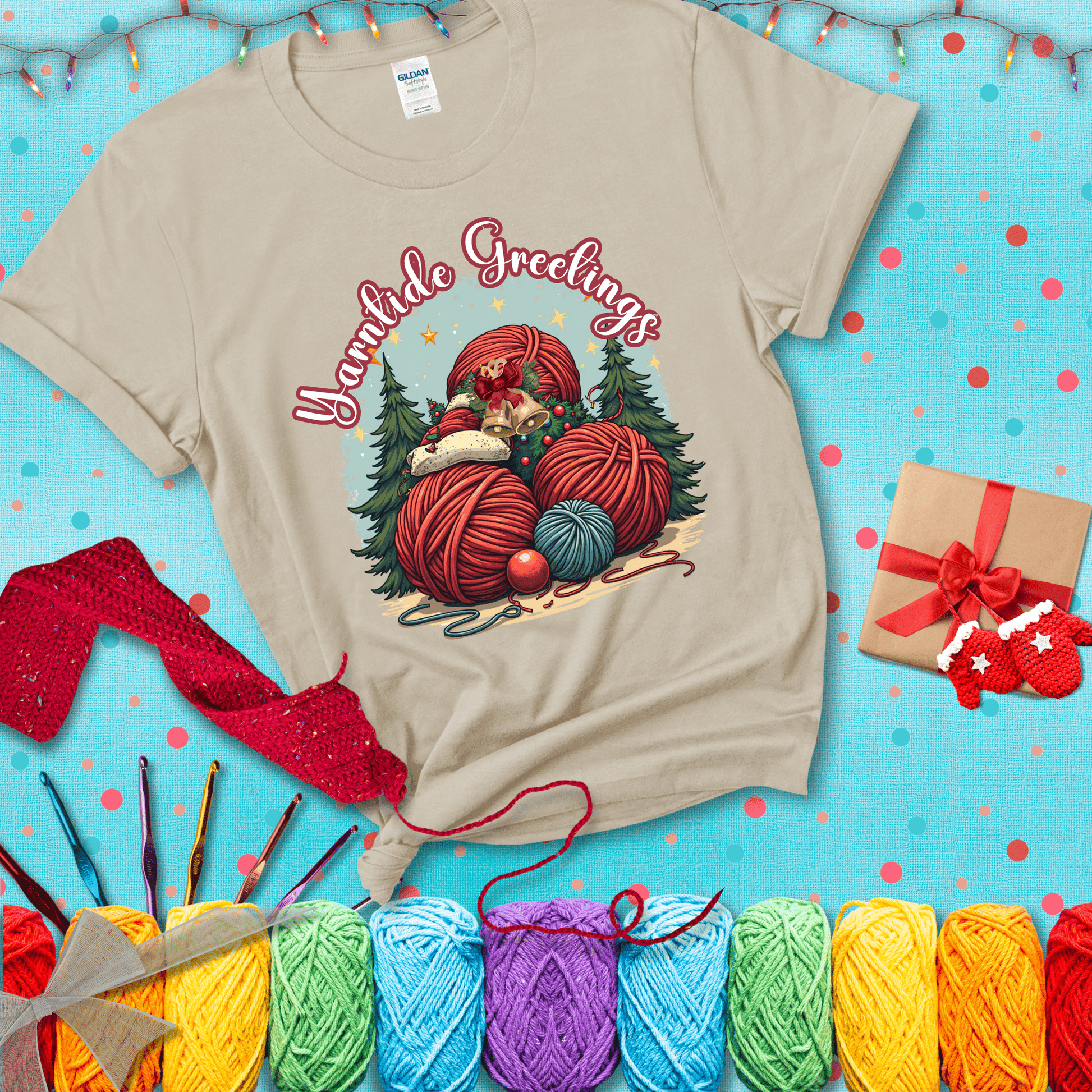 Pile of colorful yarn balls with bells, bows, and trees, with the phrase “Yarntide Greetings.” Cozy and festive holiday crochet tee, showing a beige tee with a festive Christmas background